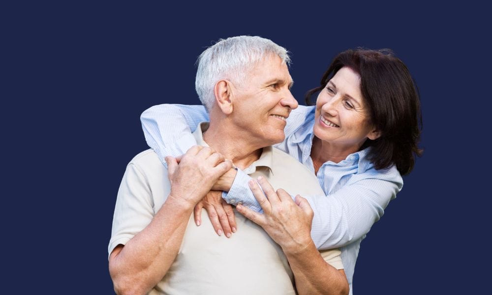 Smiling older couple embracing, representing healthy ageing and geriatric dental care.