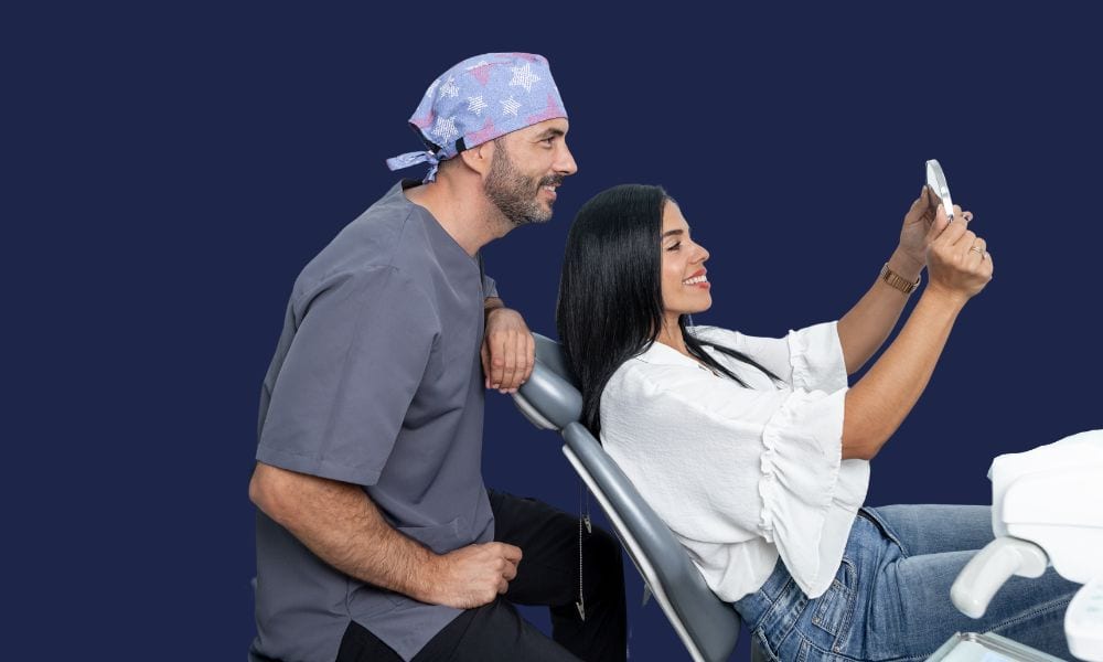 Patient admiring her smile in a mirror with her dentist, showcasing 3d printing in a dental office