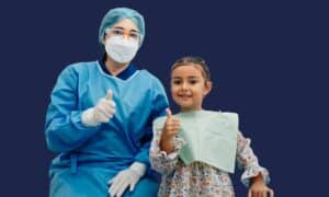 Young girl giving a thumbs up with her dentist after a successful paediatric dental appointment at OptiSmile Cape Town.